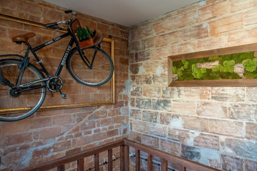 Chodba na poschodí s dekoratívnym bicyklom a tehlovým murivom